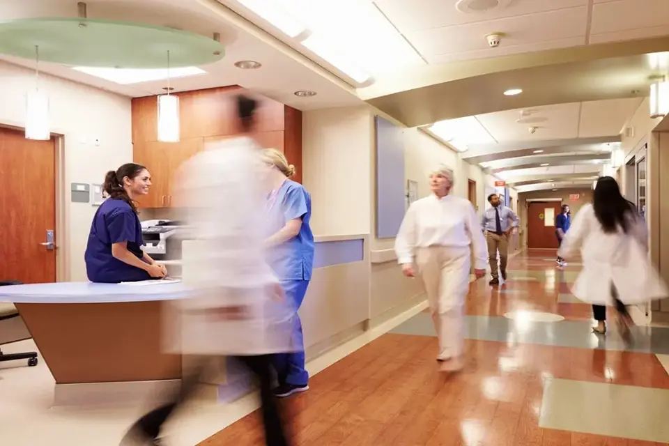 A group of people walking in a hospital hallway.