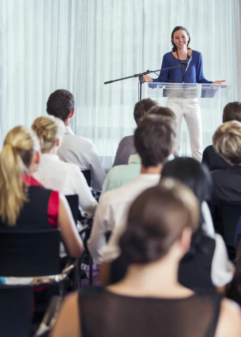 A woman is speaking to an audience in front of a crowd.